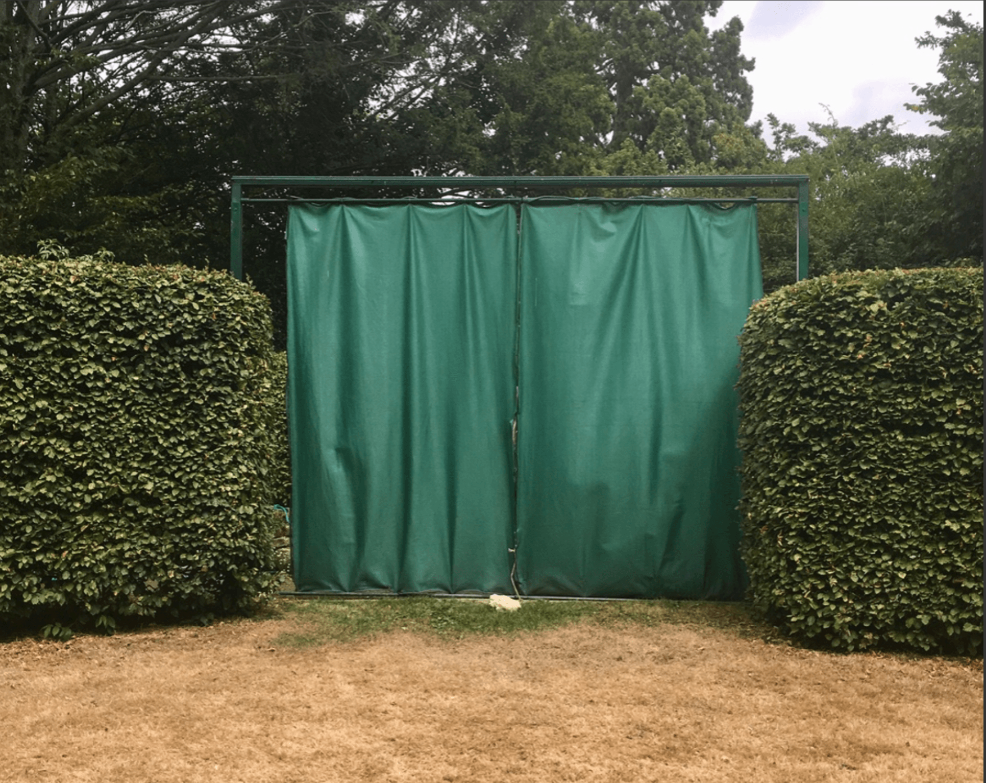 A photograph of a green screen in a park.